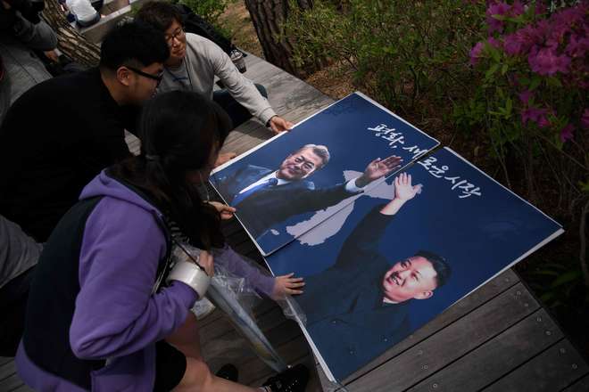 Ativistas saem com cartazes nas ruas em alusão ao encontro dos líderes - AFP / ED JONES