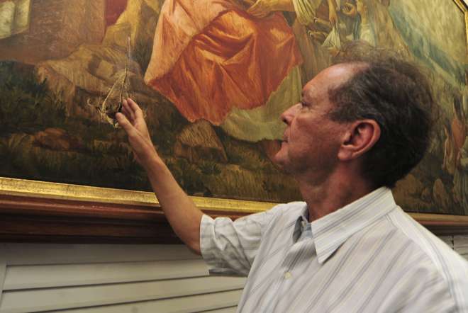 Padre Tadeu mostra o rasgo provocado na tela, que havia acabado de voltar de restauro - FÁBIO ROGÉRIO