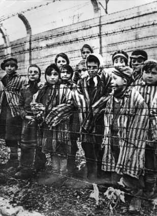 Crianças em Auschwitz são vistas por trás de uma cerca - 