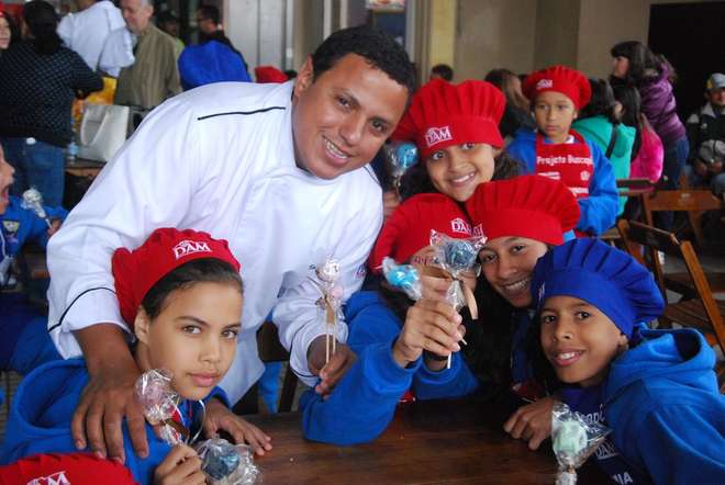 O chef Eudes de Assis e as crianças do Projeto Buscapé: aprendizado junto aos fogões transforma vidas, sim  - Divulgação